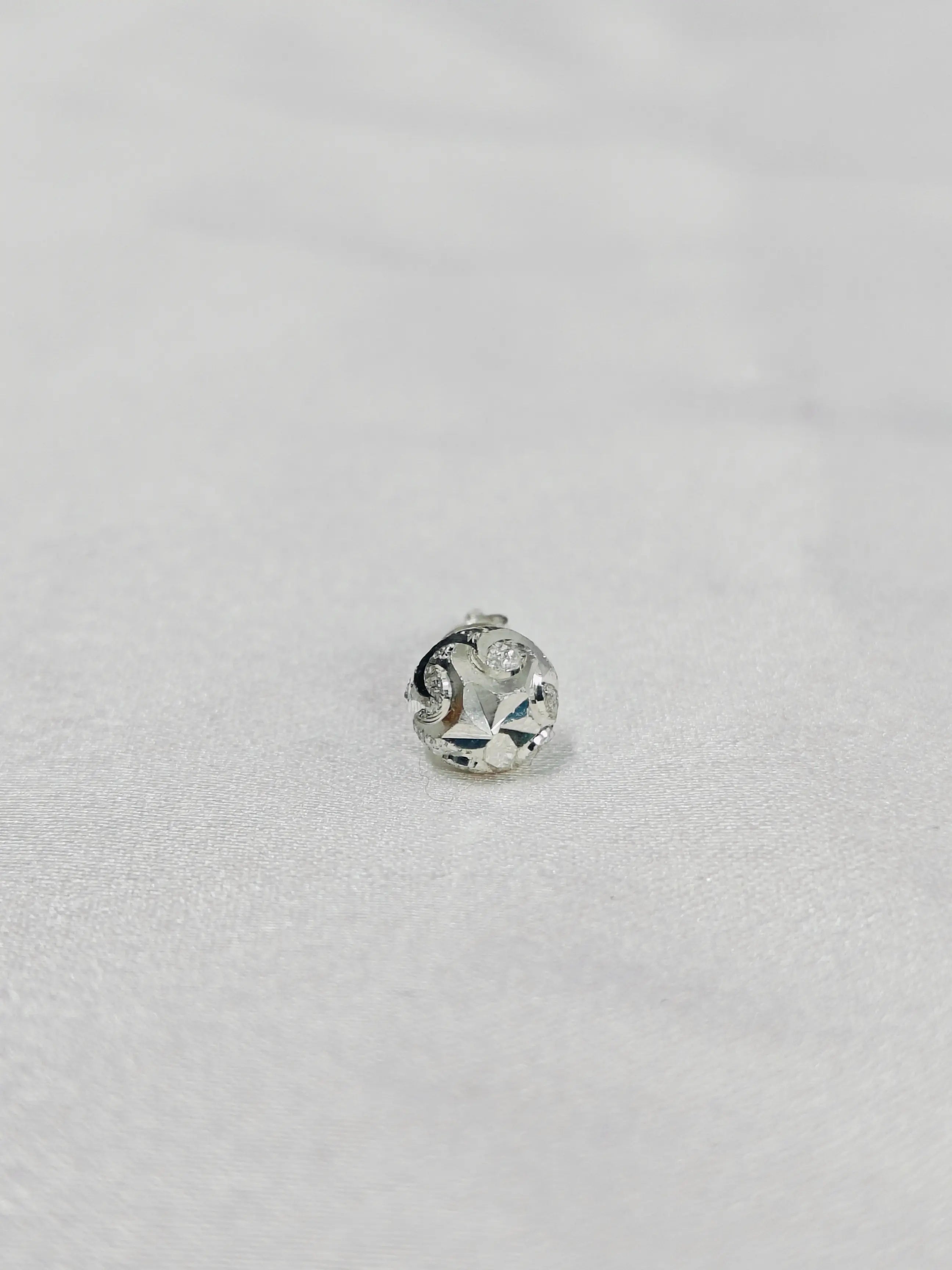 Silver ring with a diamond on a light gray background